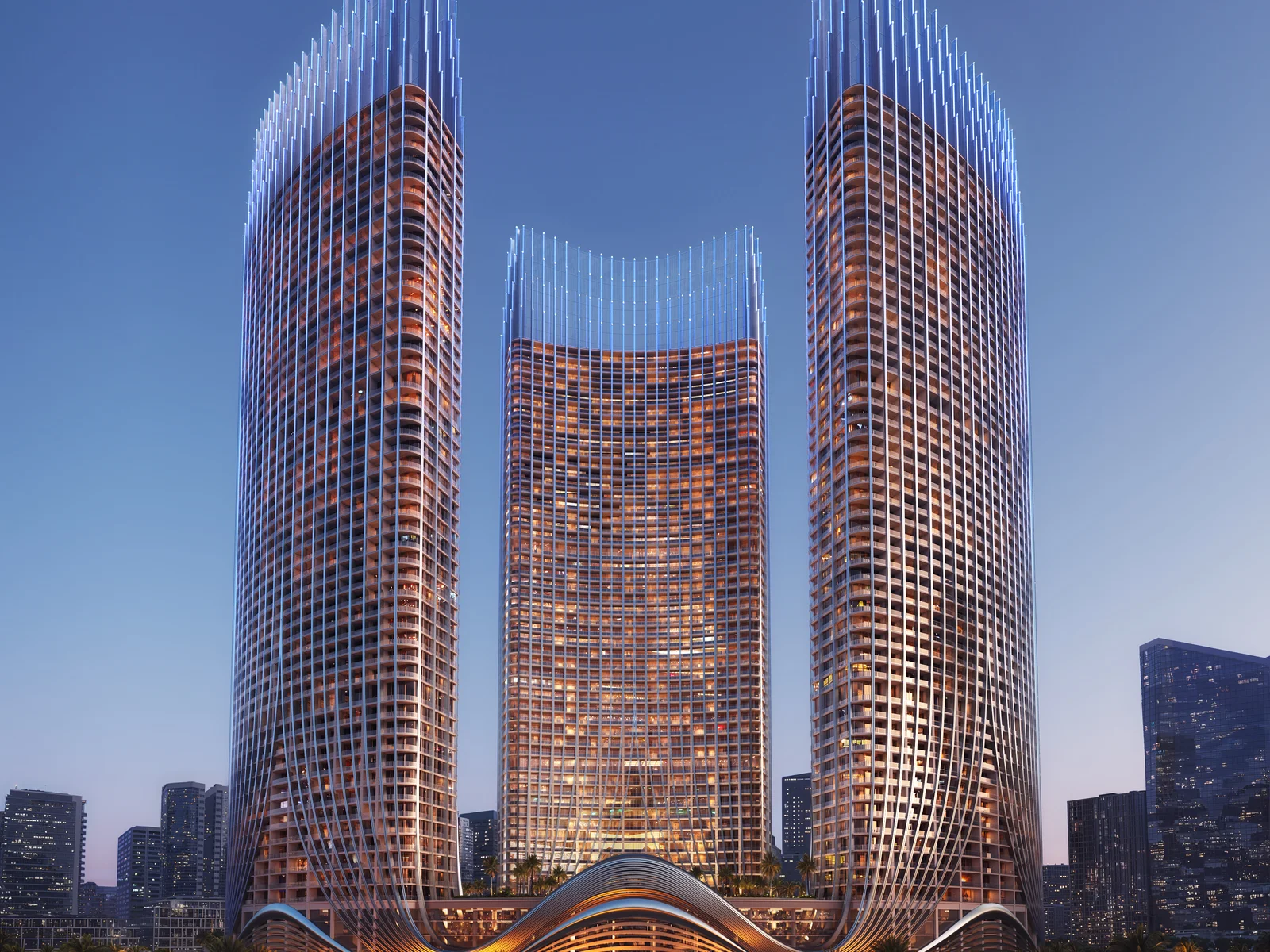Binghatti Skyrise, beleuchtete Türme in der Dämmerung mit Park