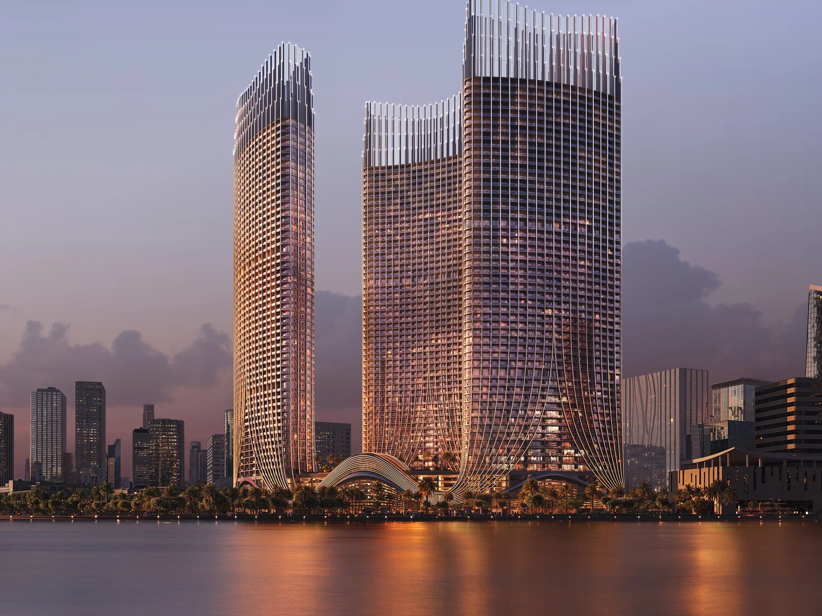 Binghatti Skyrise, drei Türme am Wasser im Sonnenuntergang mit Reflexion